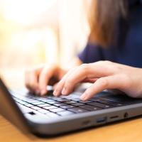En kvinde skriver på en laptop